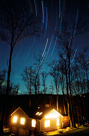Mountain home at night with stars